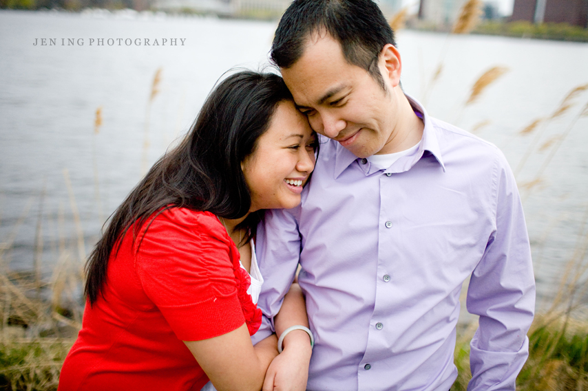 Charles River engagement session in Boston, MA - couple snuggling against reeds