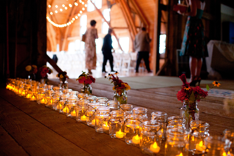 wedding reception entrance with flowers, candles, and mason jars