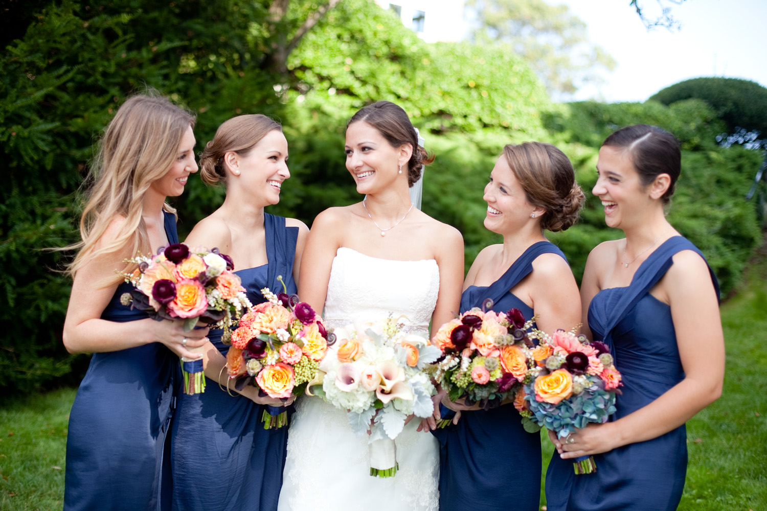 bride with navy bridemaids and dogwood floral bouquets